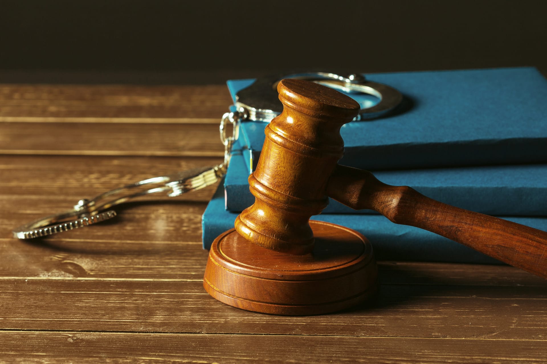 Wooden gavel resting on a table beside handcuffs and legal books, symbolizing criminal law defense for first-time assault charges in Toronto, Canada.